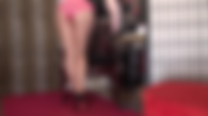 Culotte en satin rose sur collant beige brillant avec des escarpins à semelles rouges.