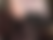 Une allumeuse érotique sensuelle aux épaules nues, aux aisselles et au décolleté en corset de cuir noir, jambes et collants semi-opaques noirs.