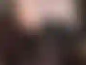 Une allumeuse érotique sensuelle aux épaules nues, aux aisselles et au décolleté en corset de cuir noir, jambes et collants semi-opaques noirs.