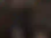 Combinaison en latex noir, masque strapon et collant blanc.