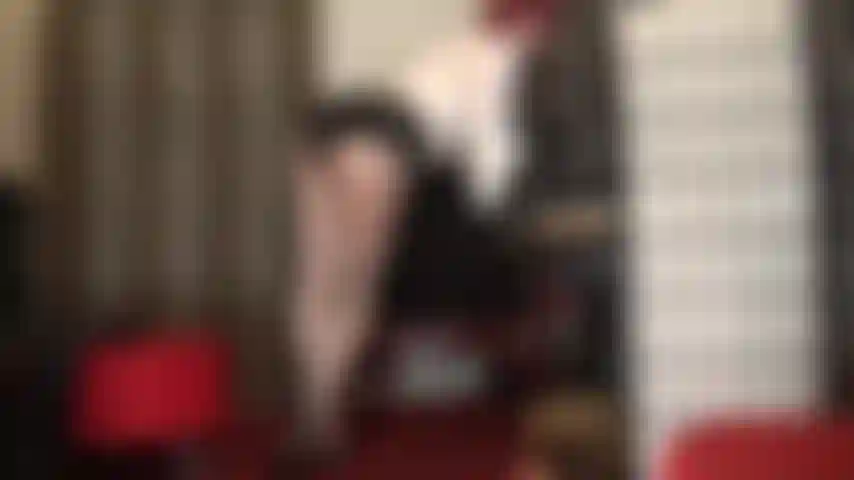 Taquinant l'amant des jambes dans de jolis collants gris argentés brillants et des mules à talons hauts.