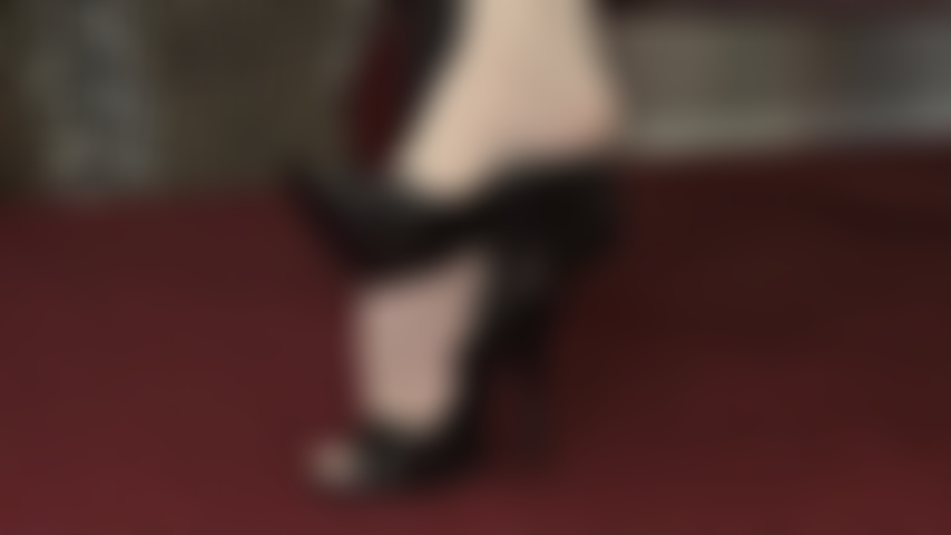 Des collants ivoire opaques pendent des pieds, de jolis peeptoes et des escarpins en cuir.