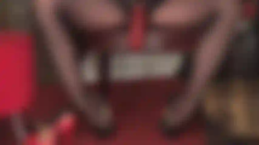 La grosse bite rouge et épaisse de la maîtresse nichée entre ses jambes de collants brillants attire certainement votre attention. Adore la bite de la maîtresse sous le bureau.