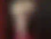 Maîtresse est sexy dans une robe en latex blanche et brillante, des gants et des couches de collants brillants avec des talons blancs.