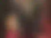 Combinaison moulante en lycra spandex, bottes en cuir, gants et long manteau en cuir.