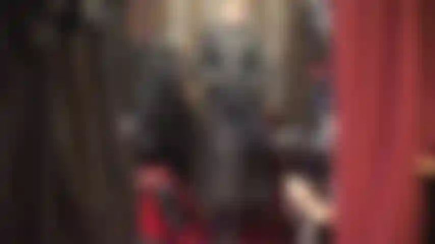 Maîtresse de culte dans un beau long manteau en cuir, de hautes bottes et des gants.