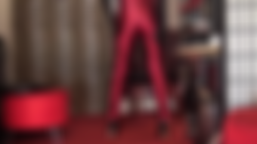 Les vêtements brillants t'excitent énormément. Maîtresse vivian associe ses gants à son pantalon en satin rouge bordeaux pour taquiner chaque goutte de sperme de ta bite.