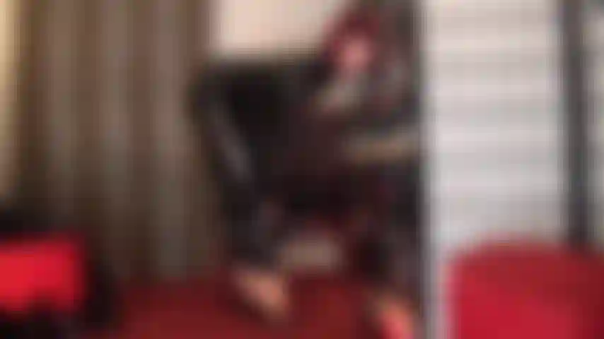 Une combinaison en pvc noir brillant et des mules sexy à talons hauts - votre déesse taquine avec ses arches de pieds incroyablement hautes en talons et collants et accorde des aperçus furtifs de ce qu'il y a sous la combinaison.