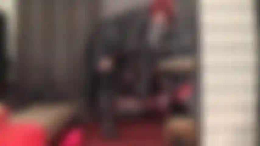 Une maîtresse en cuir vous rend folle avec des bottes hautes, un long manteau, une jupe courte et des vues tentantes sous la jupe.