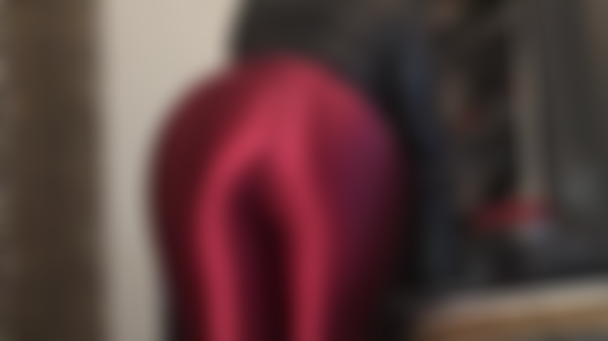 Adoratrice du cul dans un pantalon en satin rouge foncé brillant - le cul rond de la maîtresse vivian remplissant parfaitement ce pantalon disco brillant.