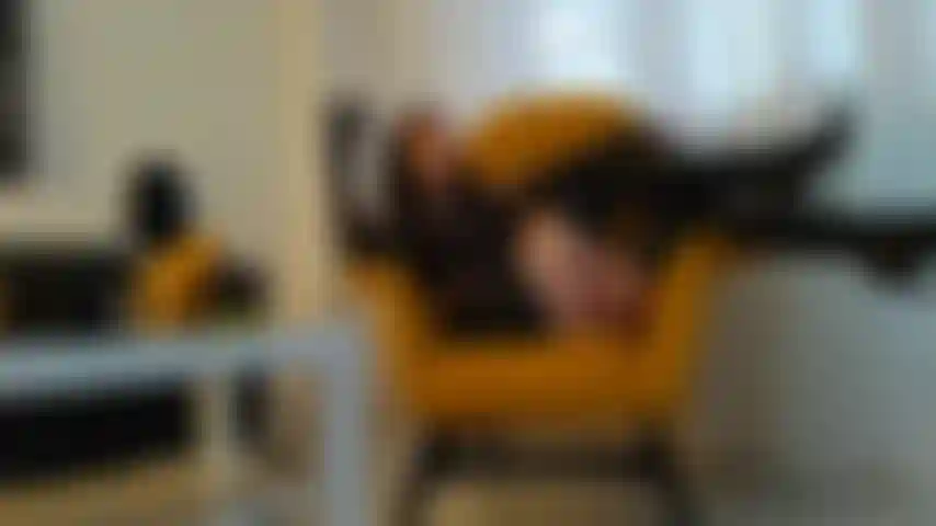 Fumant un cigare avec des gants en cuir, des bottes et une mini-jupe.