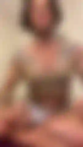 Je pose avec des muscles dans un haut beige.