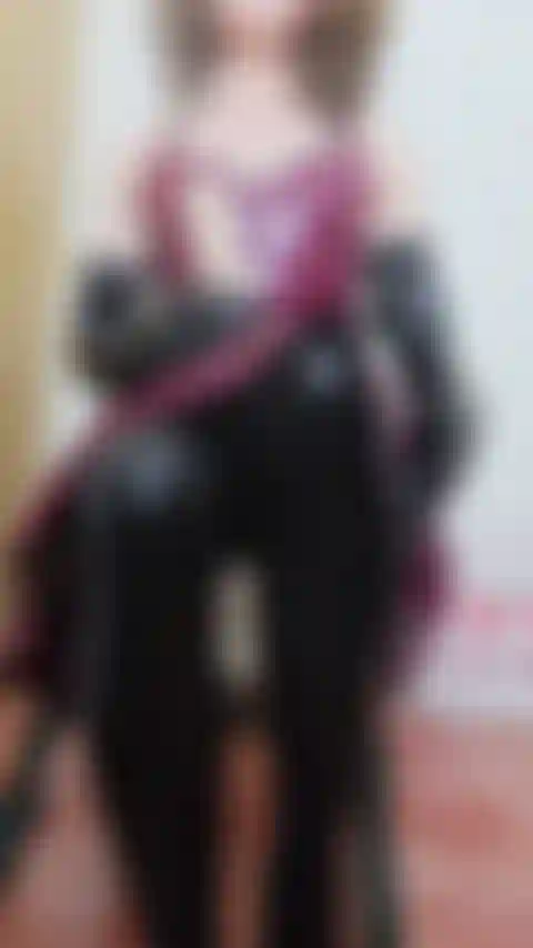 Une branlette en latex sur un gode, portant des bas en latex noir, une robe en latex prune, de très longs gants en latex avec un accent britannique, je vous parle à travers votre branlette joi.