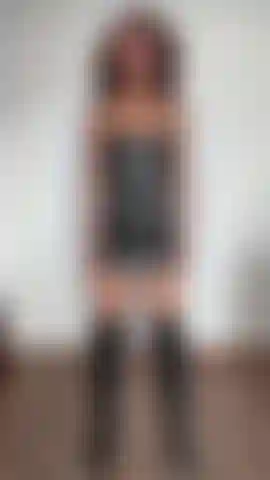 Biceps fléchis, portant une robe et des bottes en cuir noir.