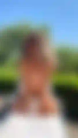 Seins nus, en train de bronzer, face à toi, à genoux.