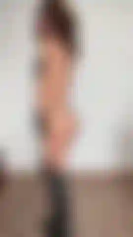 Un string noir entre mes fesses, un dos sexy, des bottes et des gants.