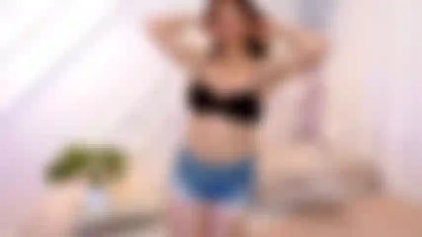 Strip sensuel et masturbation jambes ouvertes au lit.