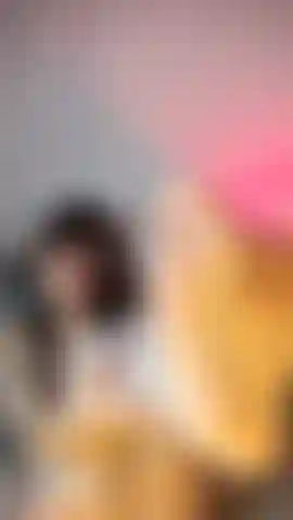 Une nana en lingerie blanche en résille, caressant ses pieds et souriant de manière ludique à la caméra.