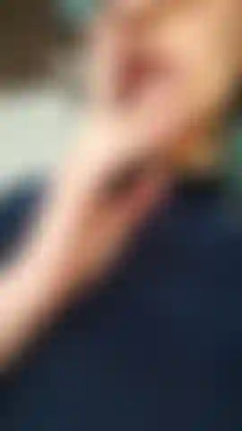 Une latina sexy qui fume, lèche les lèvres et souffle des cercles de fumée, envoie des bisous.