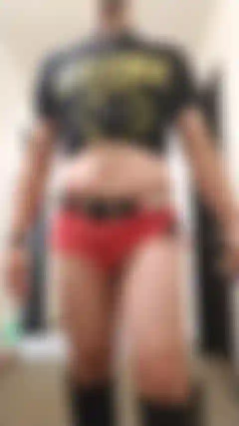 Crossdresser posant sexy dans le couloir de l'hôtel portant un short en jean et des bottes.