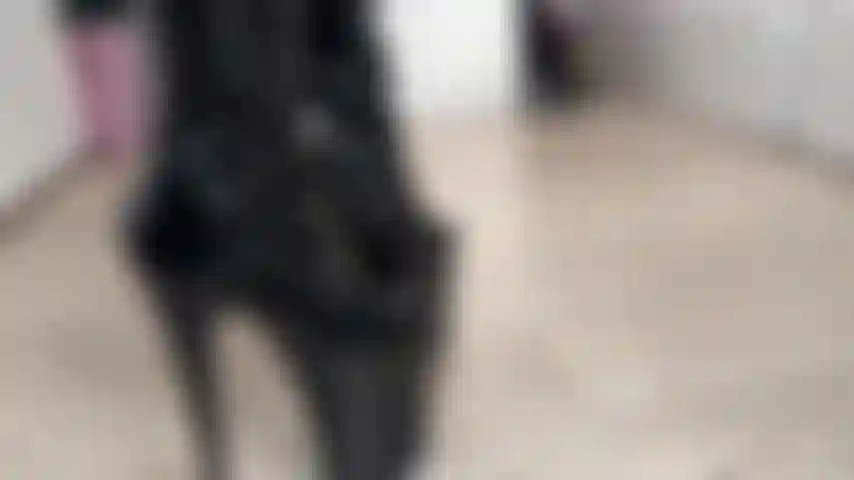 Une fille masquée en latex avec des bottes.